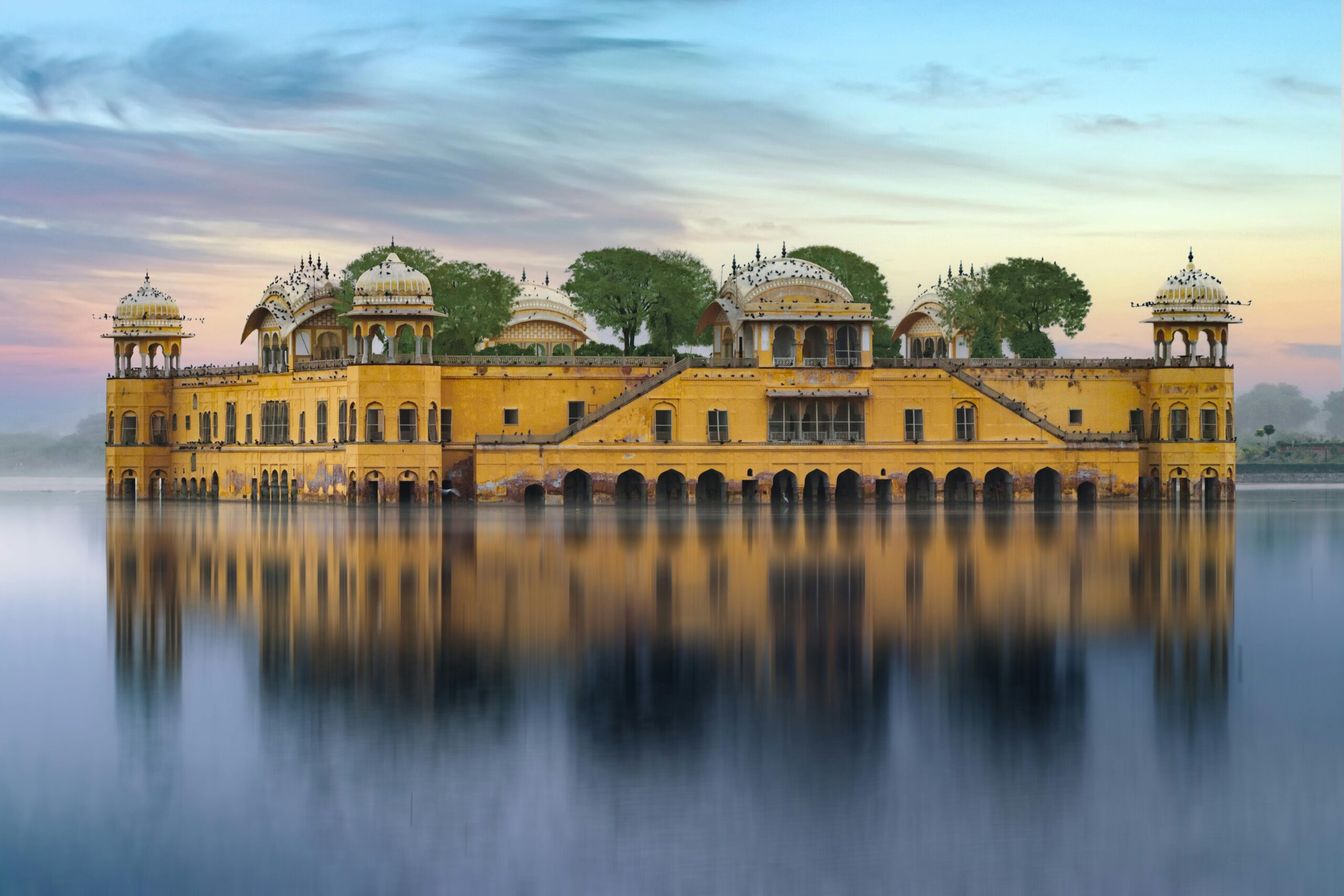 Beautiful view of Jal Mahal palace reflecting on Man Sagar Lake at sunset in Jaipur, India.