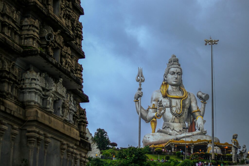 A breathtaking view of Shiva statue and temple, symbolizing spirituality and culture under overcast skies.